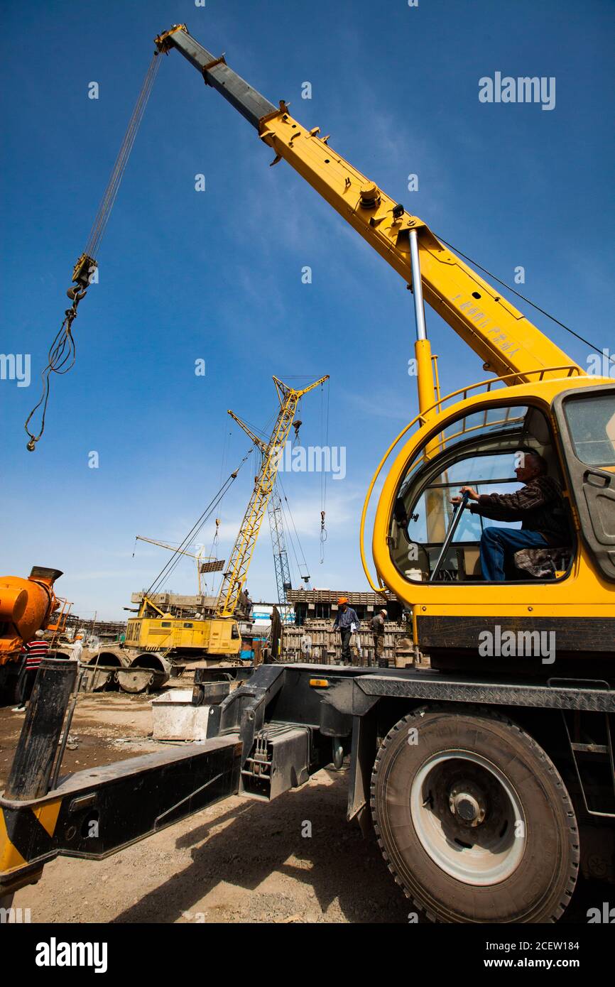 Taraz/Kazakhstan - avril 25 2012 : rénovation de l'usine d'engrais phosphoriques. Grue de camion avec opérateur et grue à poutre en service. Banque D'Images