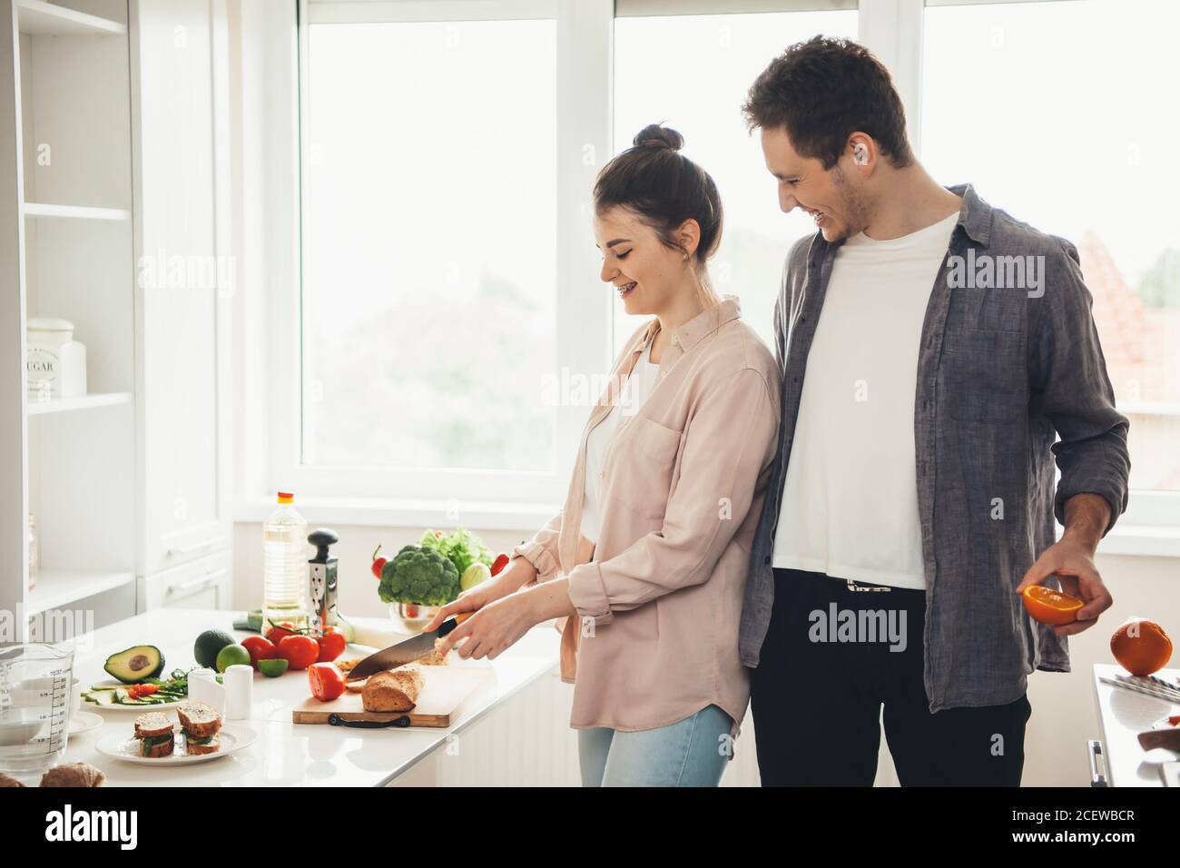 Un jeune couple caucasien prépare des aliments ensemble dans la cuisine en tranches fruits et légumes Banque D'Images