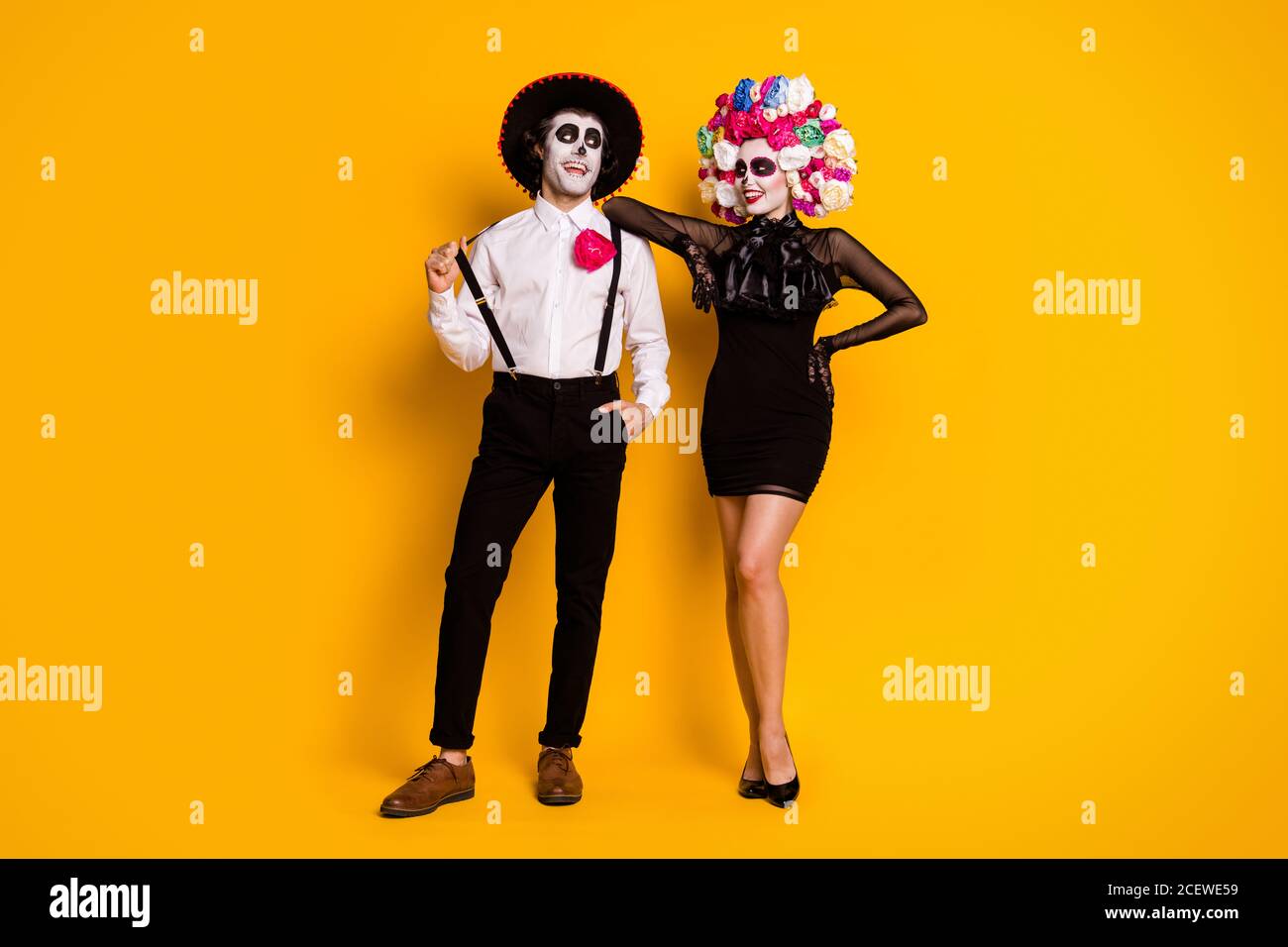 Vue sur toute la longueur de son corps elle joli-look glamour gai couple posant calavera fête carnaval boîte de nuit événement isolé lumineux Banque D'Images