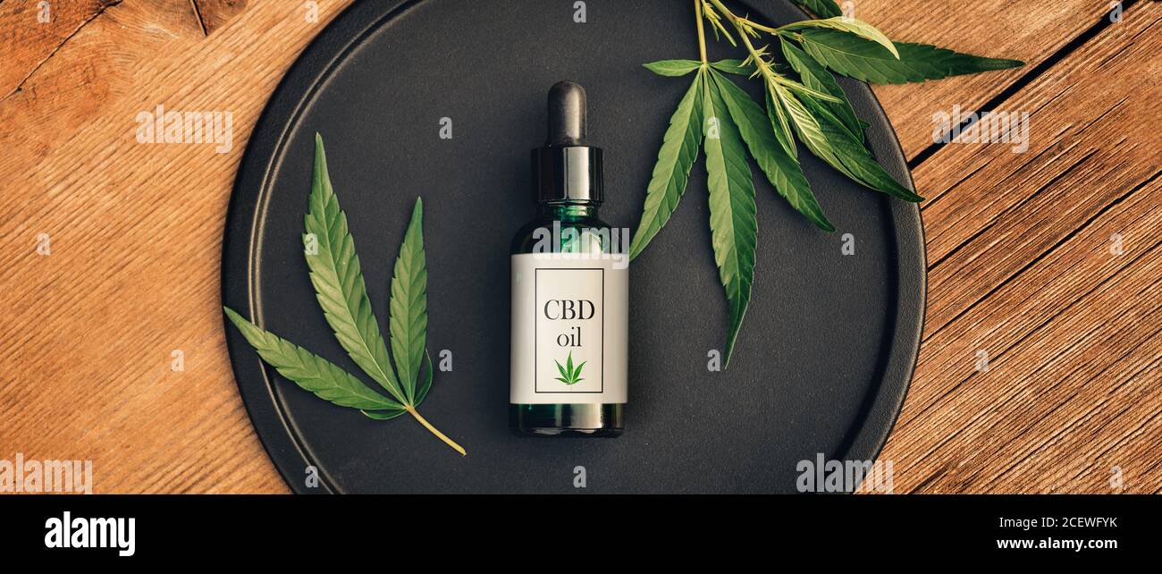 Cannabis produit médical, huile de CBD, avec feuilles de chanvre sur une table en bois Banque D'Images
