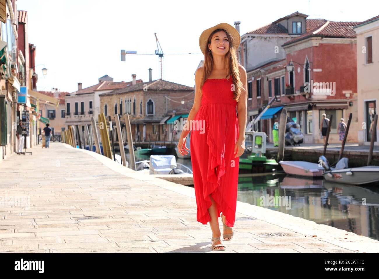 Femme élégante en robe longue rouge marchant dans la vieille ville de  Murano, Venise, Italie Photo Stock - Alamy