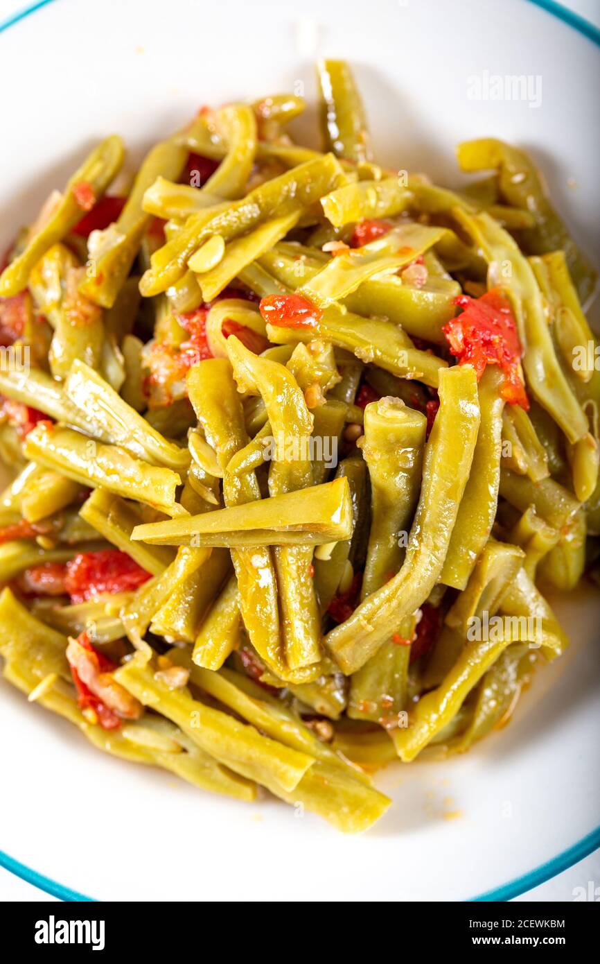 Haricots verts turcs (Fasoulia) dans un plat sur fond blanc. Banque D'Images