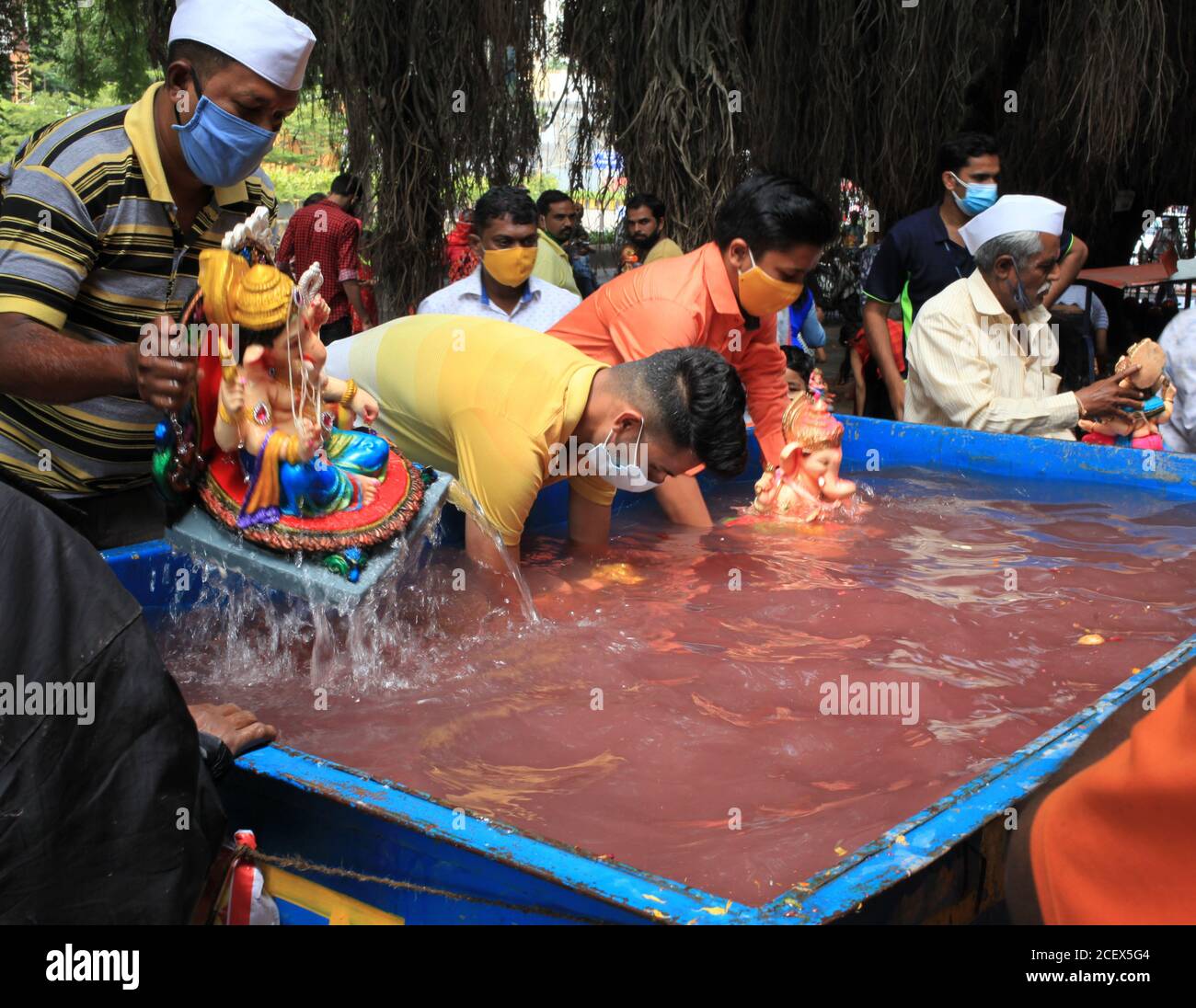 Idoles de Lord Ganesha étant immergées dans un réservoir communautaire par des dévotés dans le cadre d'un rituel annuel. Lieu:Nashik, Maharashtra, Inde. Date : septembre Banque D'Images