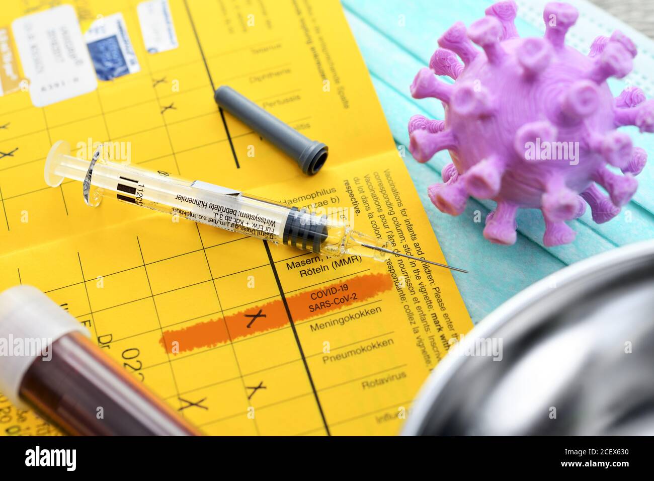Seringue, tube de prélèvement sanguin, modèle de coronavirus et carte de vaccination, vaccination par corona Banque D'Images