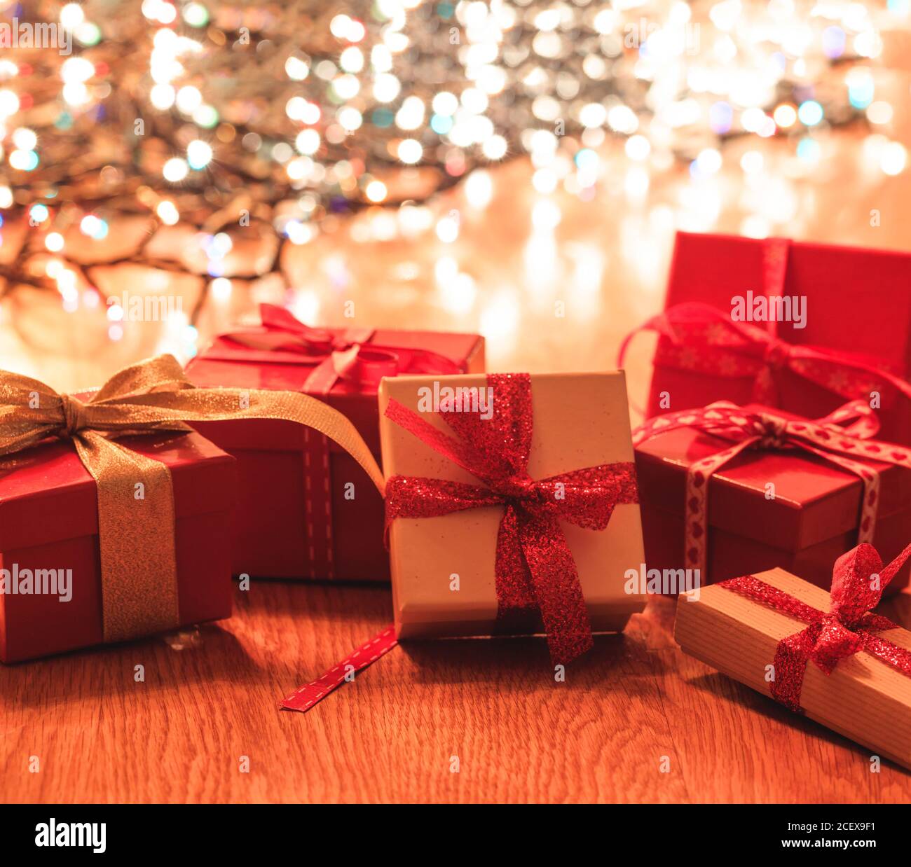 Cadeaux de Noël sur parquet, Noël lumières bokeh fond. Décoration de fête de Noël, cadeaux pour la famille et les amis Banque D'Images