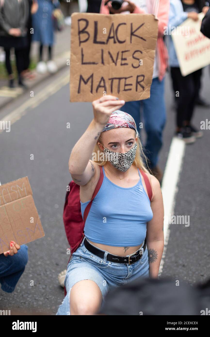 Une jeune fille qui prend le genou et tient un signe de protestation à la marche du million de personnes, Londres, 30 août 2020 Banque D'Images