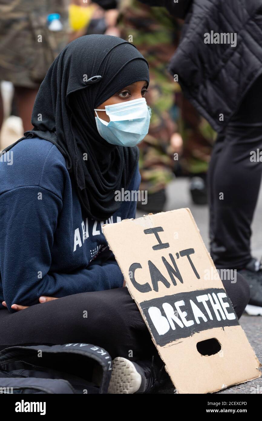 Une jeune fille musulmane est assise avec un écriteau au million People March, Londres, 30 août 2020 Banque D'Images