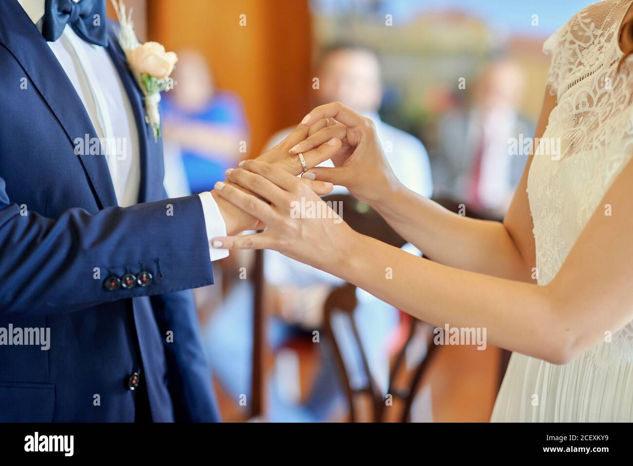 Vue latérale des anneaux de mariage de la petite mariée et du marié pendant la cérémonie dans l'église Banque D'Images