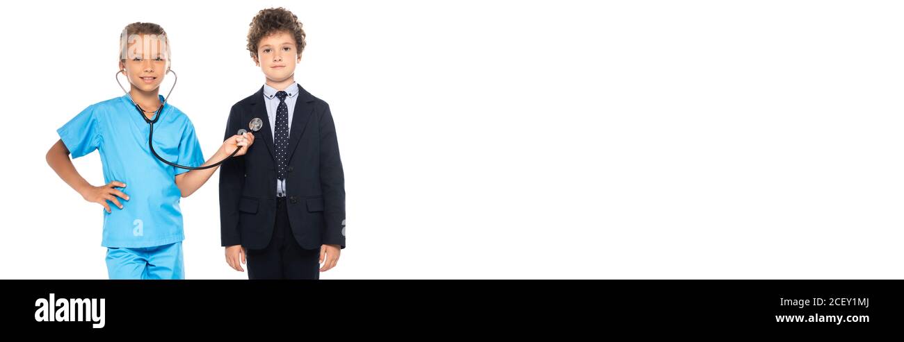 image horizontale de l'enfant en costume de médecin examinant le curly enfant en tenue habillée isolé sur blanc Banque D'Images