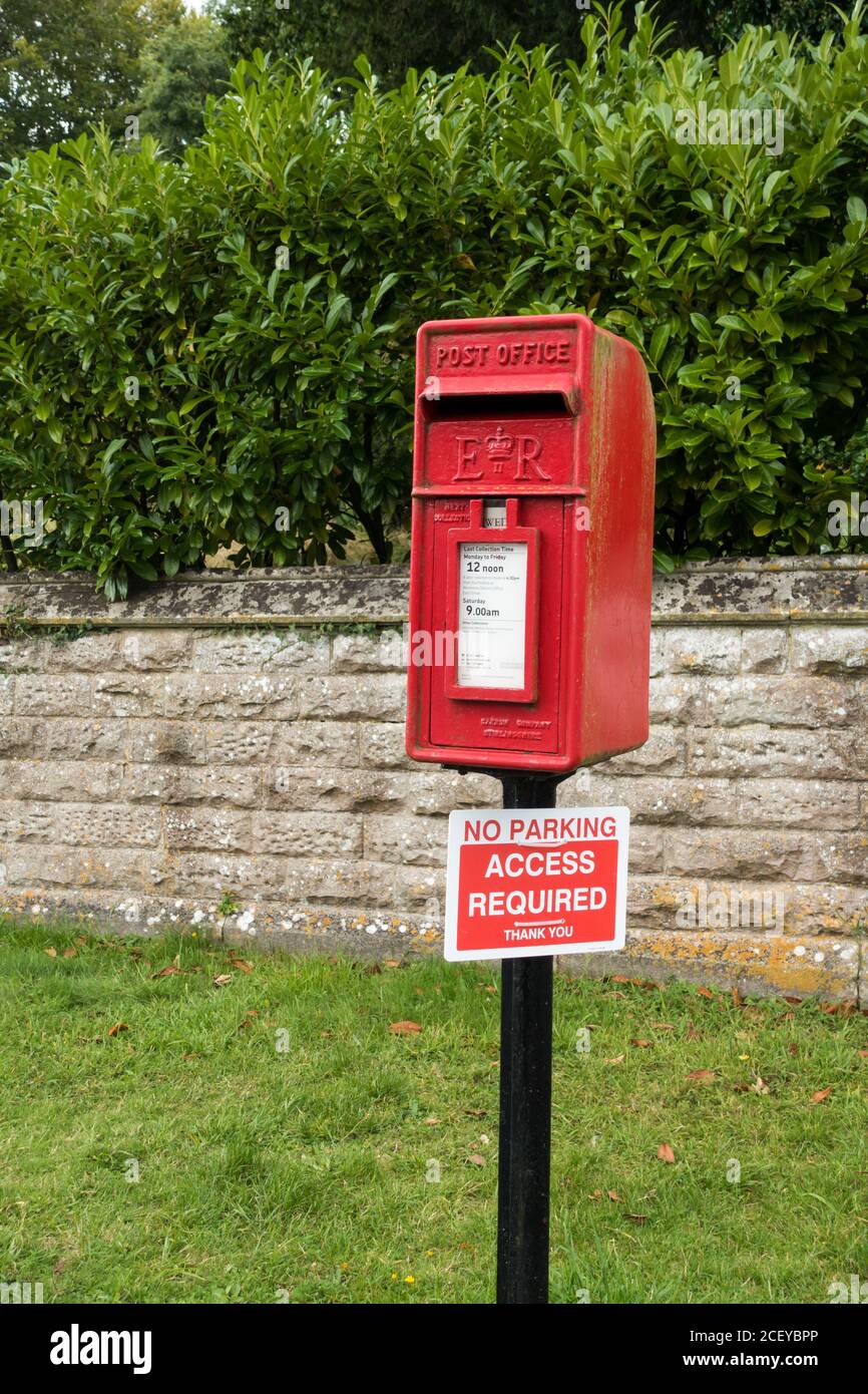 Une boîte aux lettres rouge rurale du bureau de poste de Royal Mail avec un avis « pas de parking » « accès requis ». Witchampton, Dorset, Angleterre Banque D'Images
