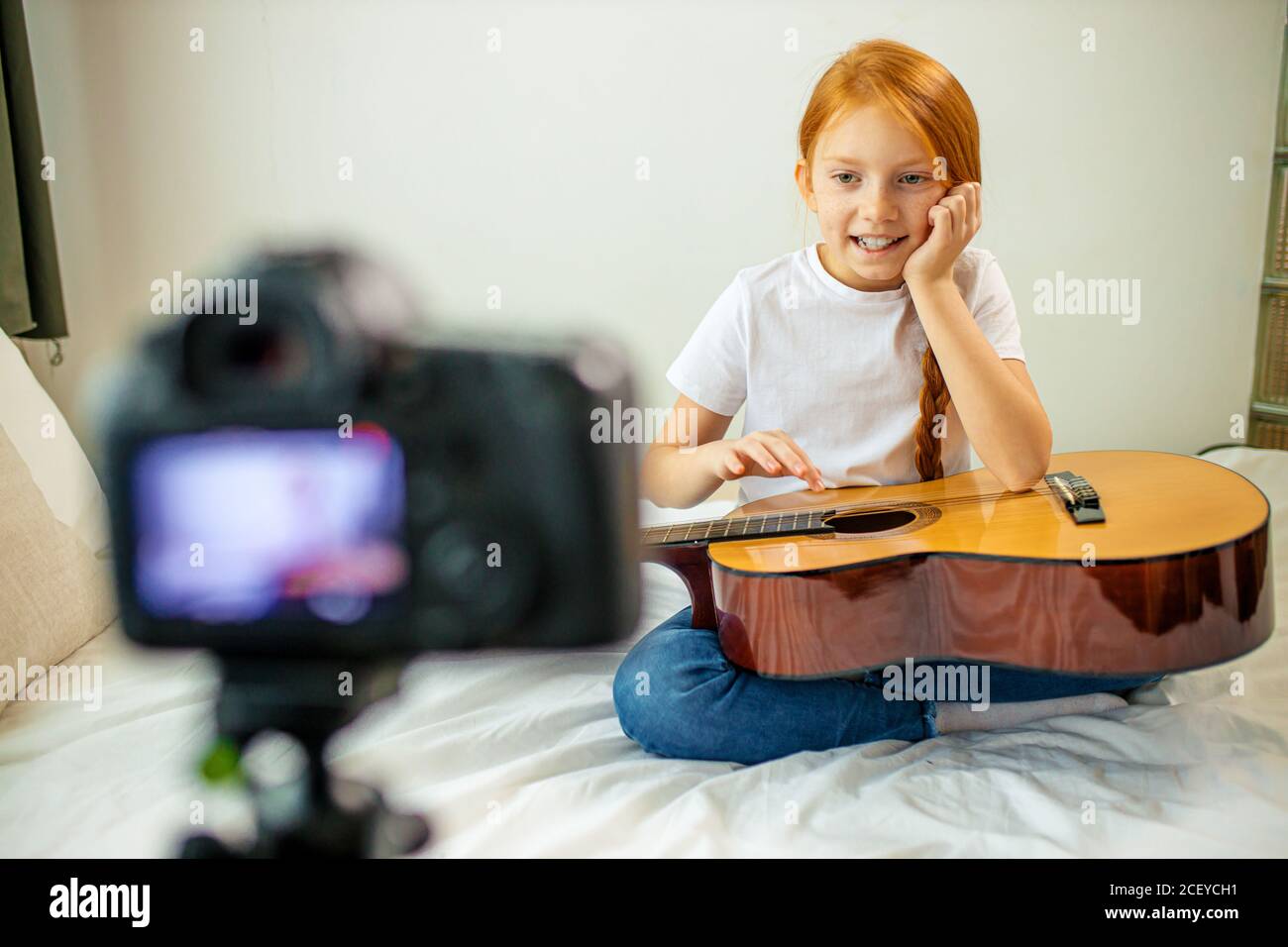mignon adorable enfant blogueur jouer de la guitare, parler à la caméra comment elle a appris à jouer de la guitare acoustique, elle est autodidacte Banque D'Images