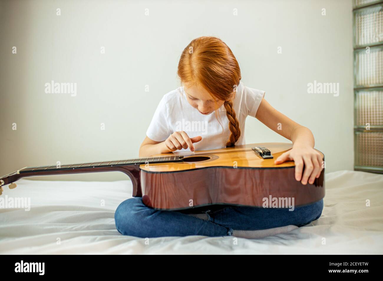 mignon adorable enfant blogueur jouer de la guitare, parler à la caméra comment elle a appris à jouer de la guitare acoustique, elle est autodidacte Banque D'Images