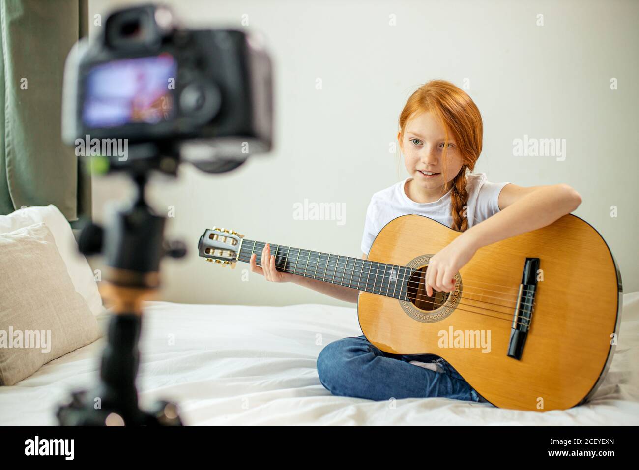 mignon adorable enfant blogueur jouer de la guitare, parler à la caméra comment elle a appris à jouer de la guitare acoustique, elle est autodidacte Banque D'Images