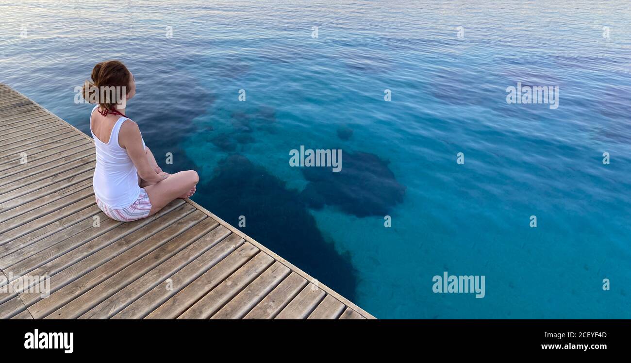 femme assise en bois sur la mer Banque D'Images