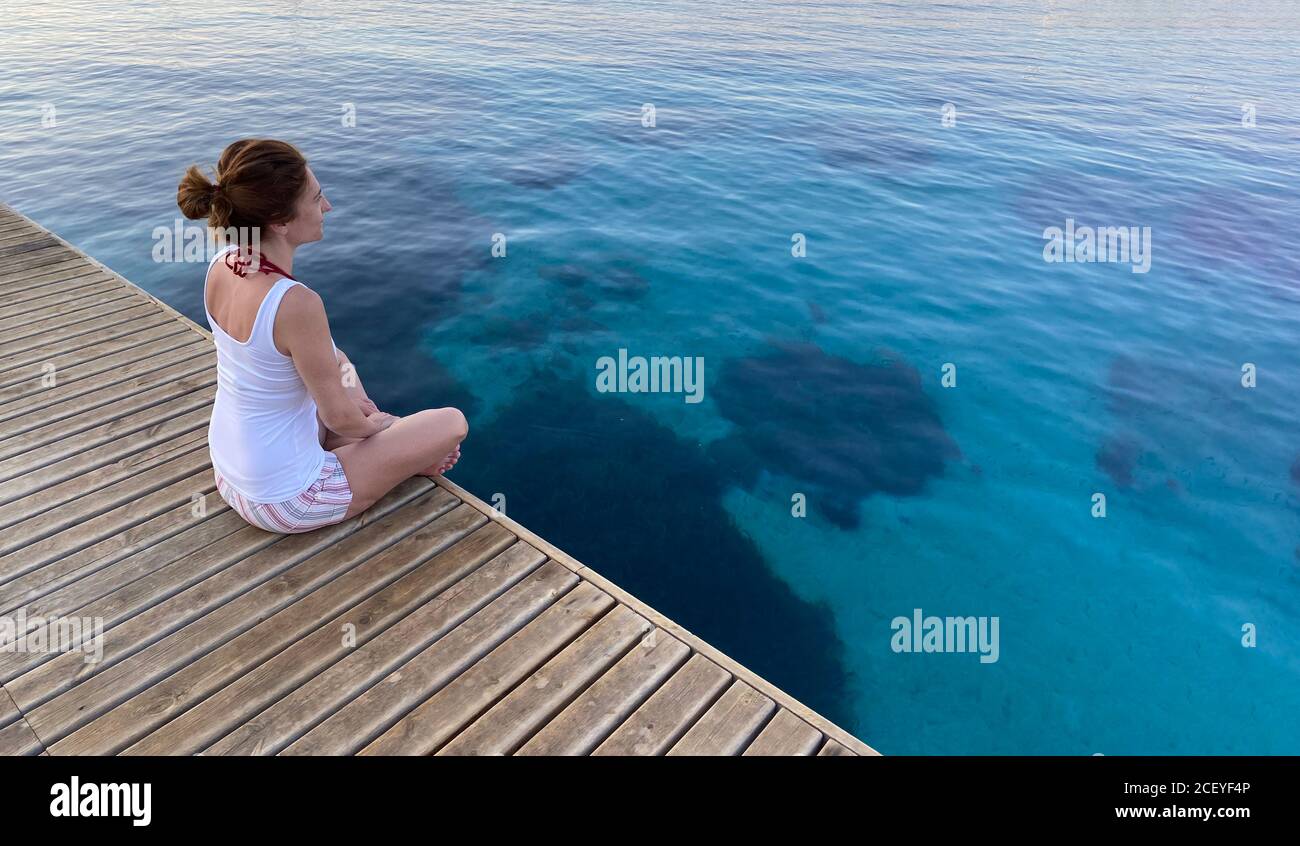 femme assise en bois sur la mer Banque D'Images