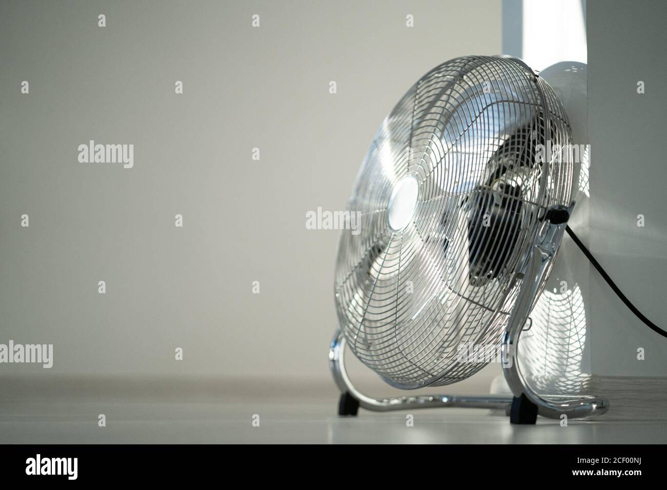 Ventilateur de ventilation en métal argenté sur parquet à la maison. Espace de copie Banque D'Images