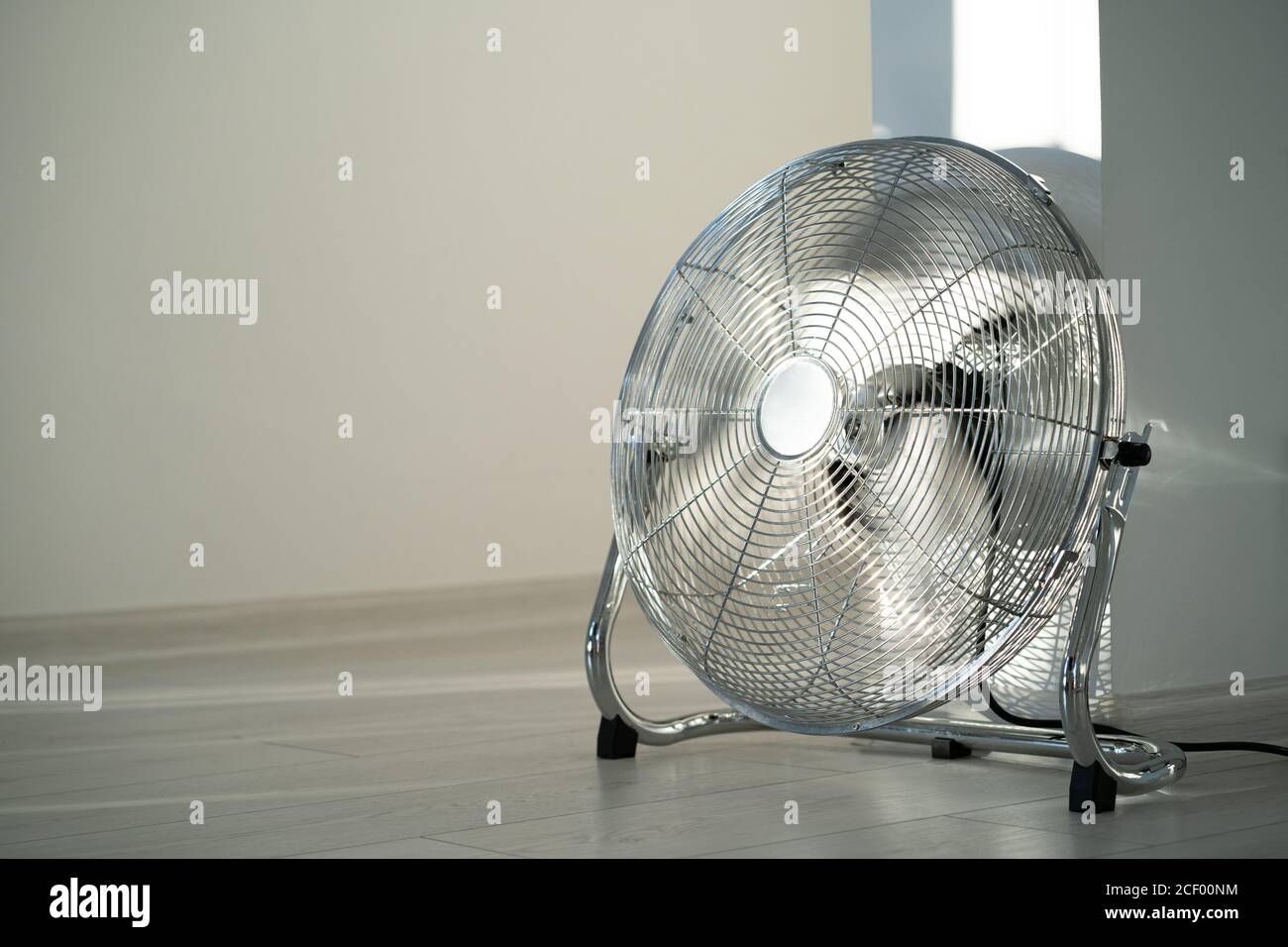 Ventilateur de ventilation en métal argenté sur parquet à la maison. Espace de copie Banque D'Images