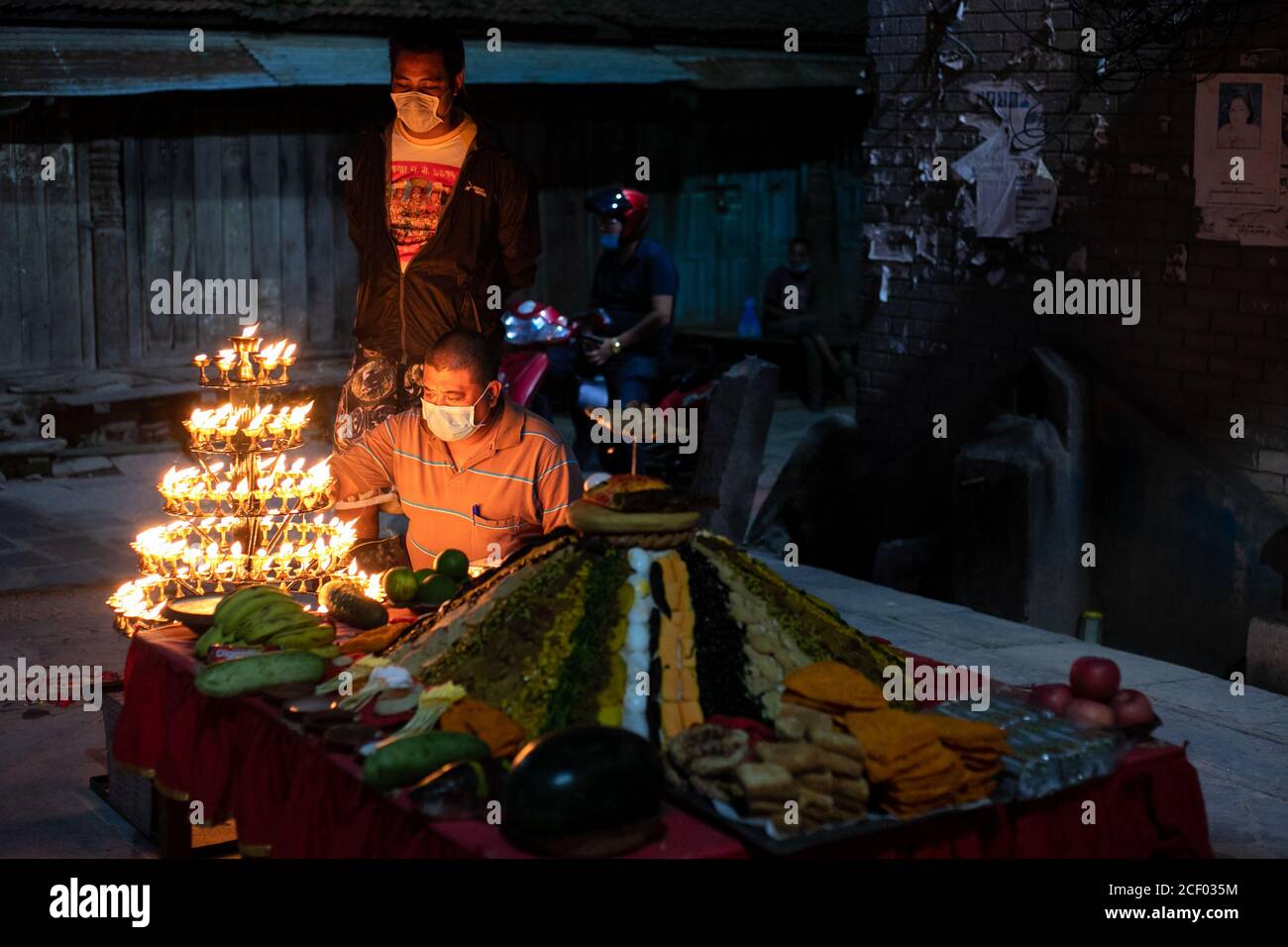 Un dévot hindou népalais portant un masque de visage offre des prières à côté du Samyabaji pendant le festival Indra Jatra.Indra Jatra, le festival de rein de Dieu est célébré avec beaucoup de fanfare dans la vallée de Katmandou. Dans ce festival de huit jours, les Chariots de la Déesse vivante Kumari et les dieux vivants Ganesh et Bhairab sont tirés dans diverses parties de la ville, mais en raison de la pandémie Covid-19 pour la première fois dans l'histoire le traitement de chars a été annulé. Les pulu kisi et lakhey ont été adorés à leurs maisons. Banque D'Images