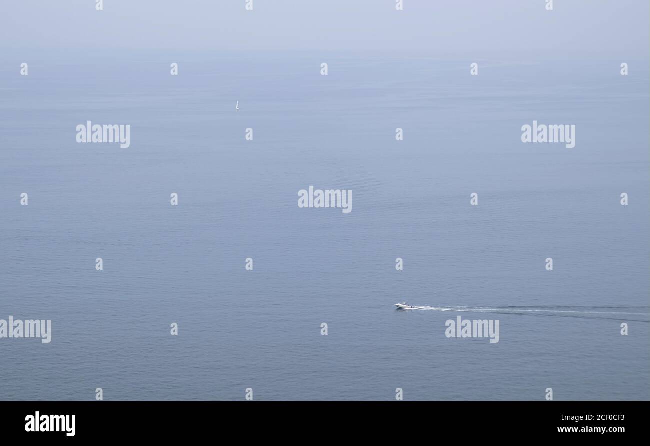 Vue sur la baie de Sagami par une journée de ciel couvert, avec un bateau à moteur visible en premier plan et un voilier à peine visible en arrière-plan Banque D'Images