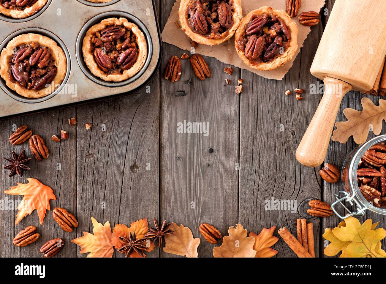 Cadre de cuisson d'automne avec tartes de pacan, feuilles et noix sur fond de bois Banque D'Images