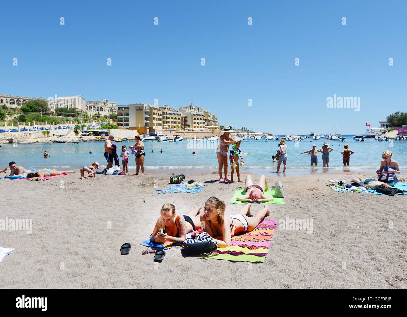 La plage animée de St George's Bay à St Julian, Malte. Banque D'Images