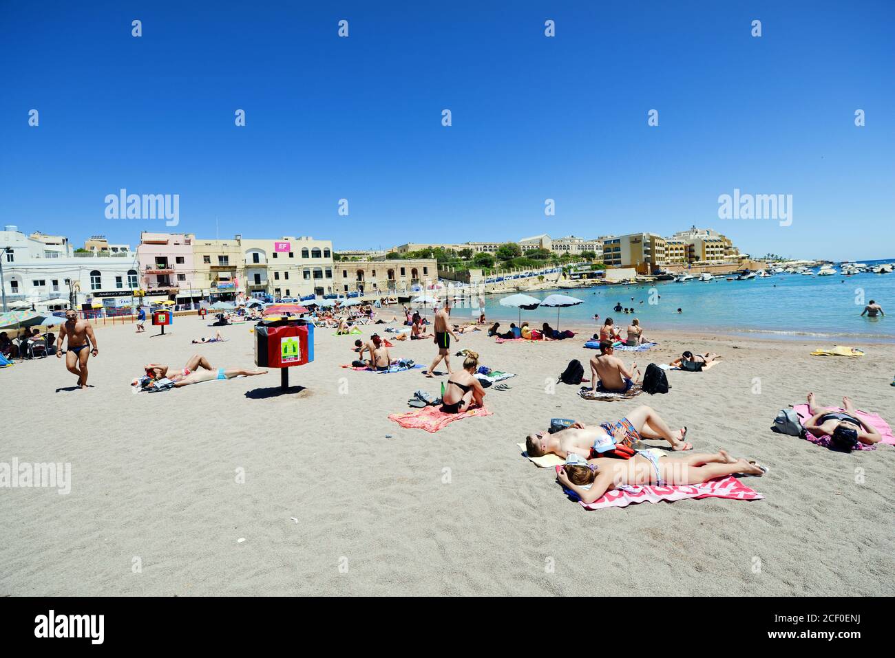 La plage animée de St George's Bay à St Julian, Malte. Banque D'Images
