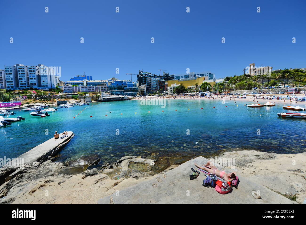 La plage animée de St George's Bay à St Julian, Malte. Banque D'Images