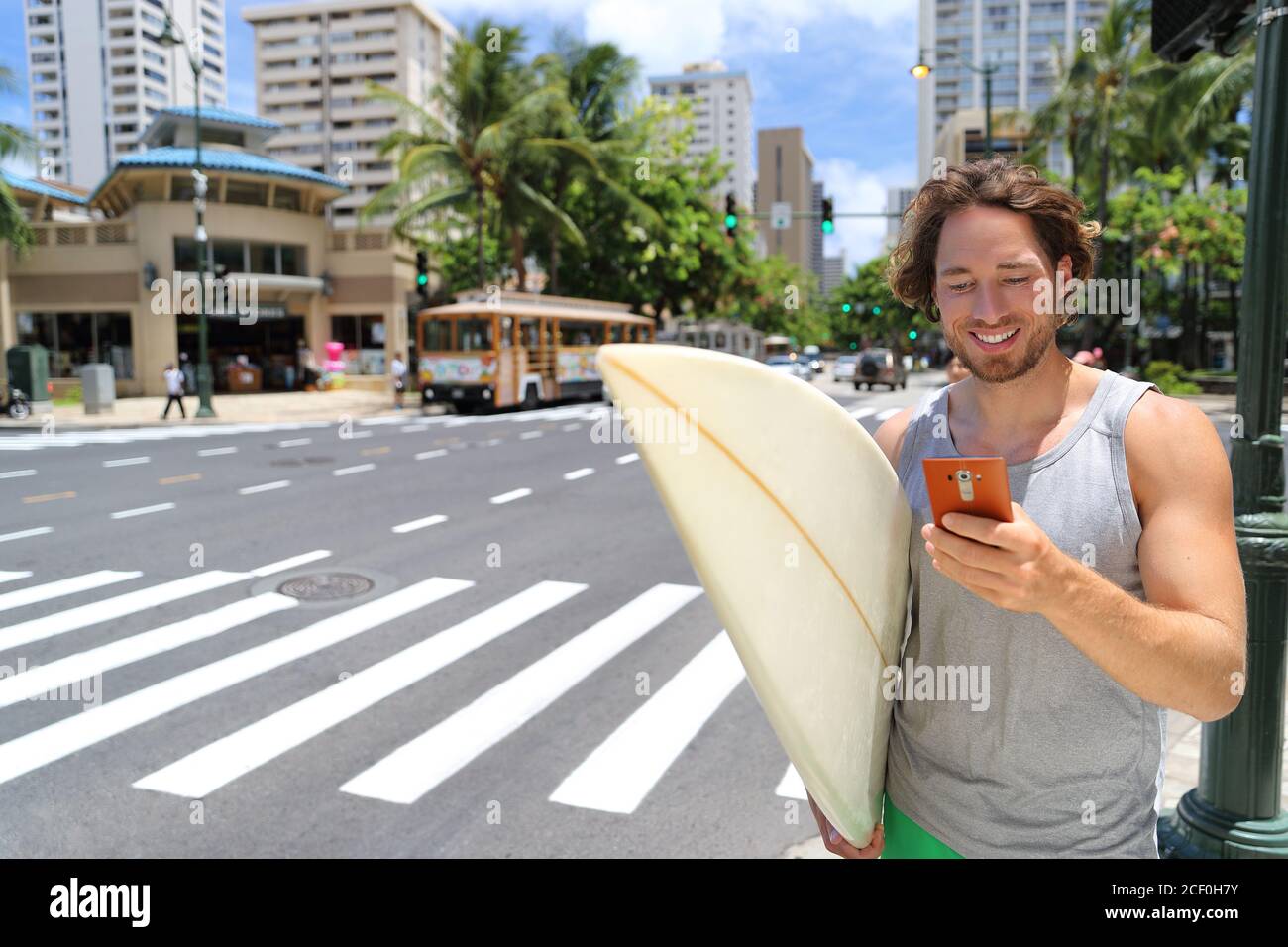Hawaï surfeur homme Honolulu style de vie à l'aide du téléphone Banque D'Images