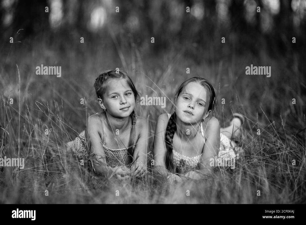 Deux filles de dix ans posent pour une photo dans le parc. Photographie en noir et blanc. Banque D'Images