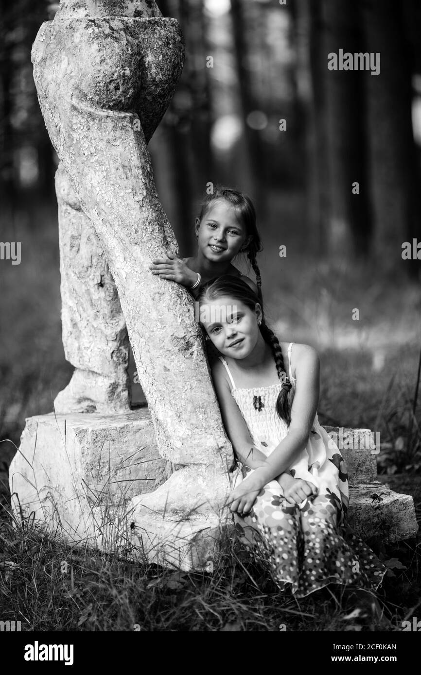 Deux petites filles posent pour une photo dans le parc. Photographie en noir et blanc. Banque D'Images