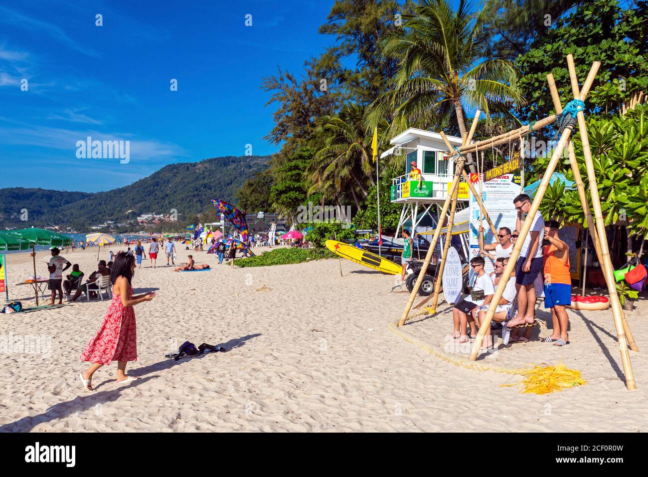 Famille touristique et balançoire en bois sur la plage de Patong, Phuket, Thaïlande Banque D'Images