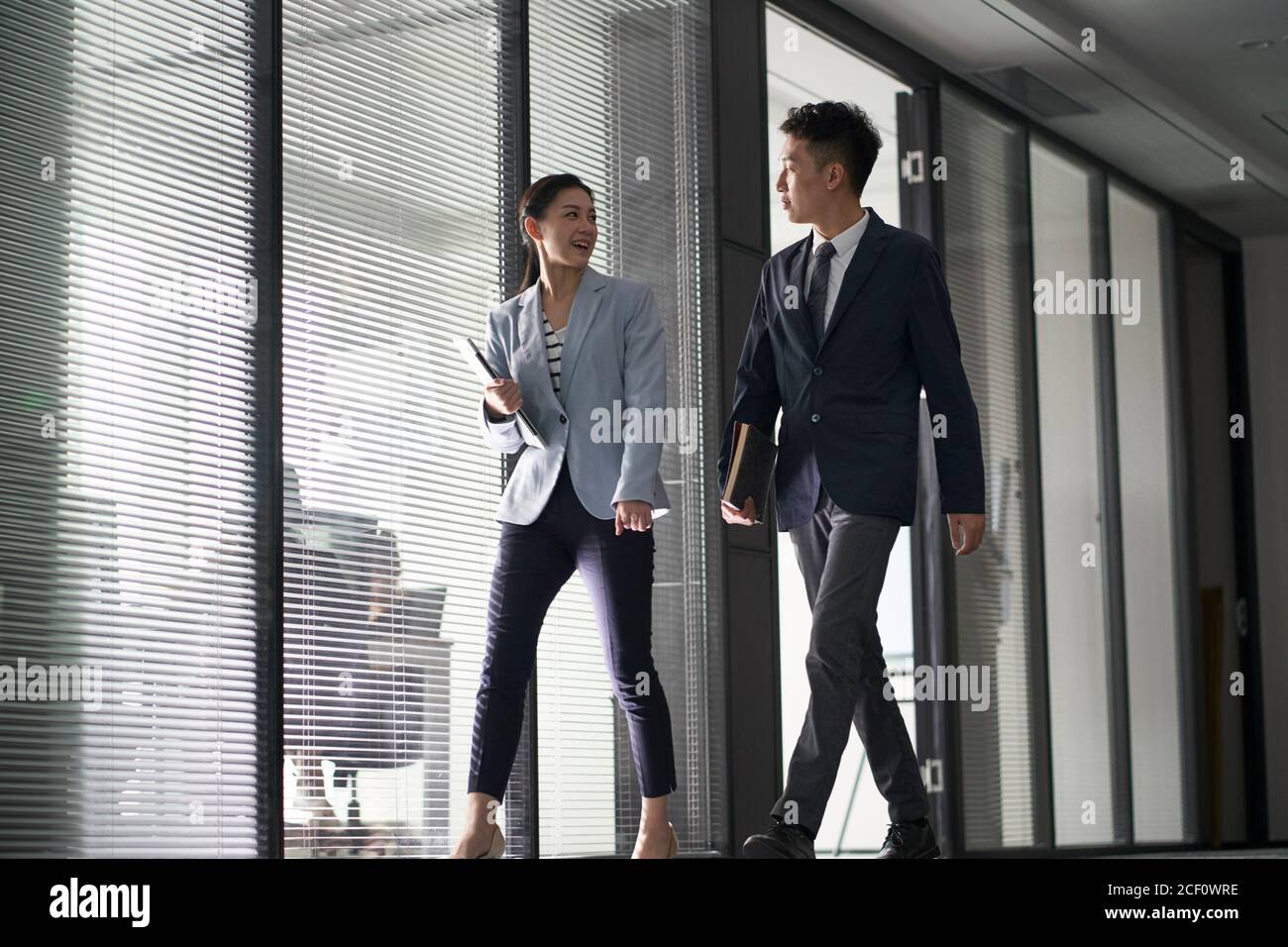 deux hommes d'affaires asiatiques sur le chemin de la rencontre en marchant dans le bureau Banque D'Images