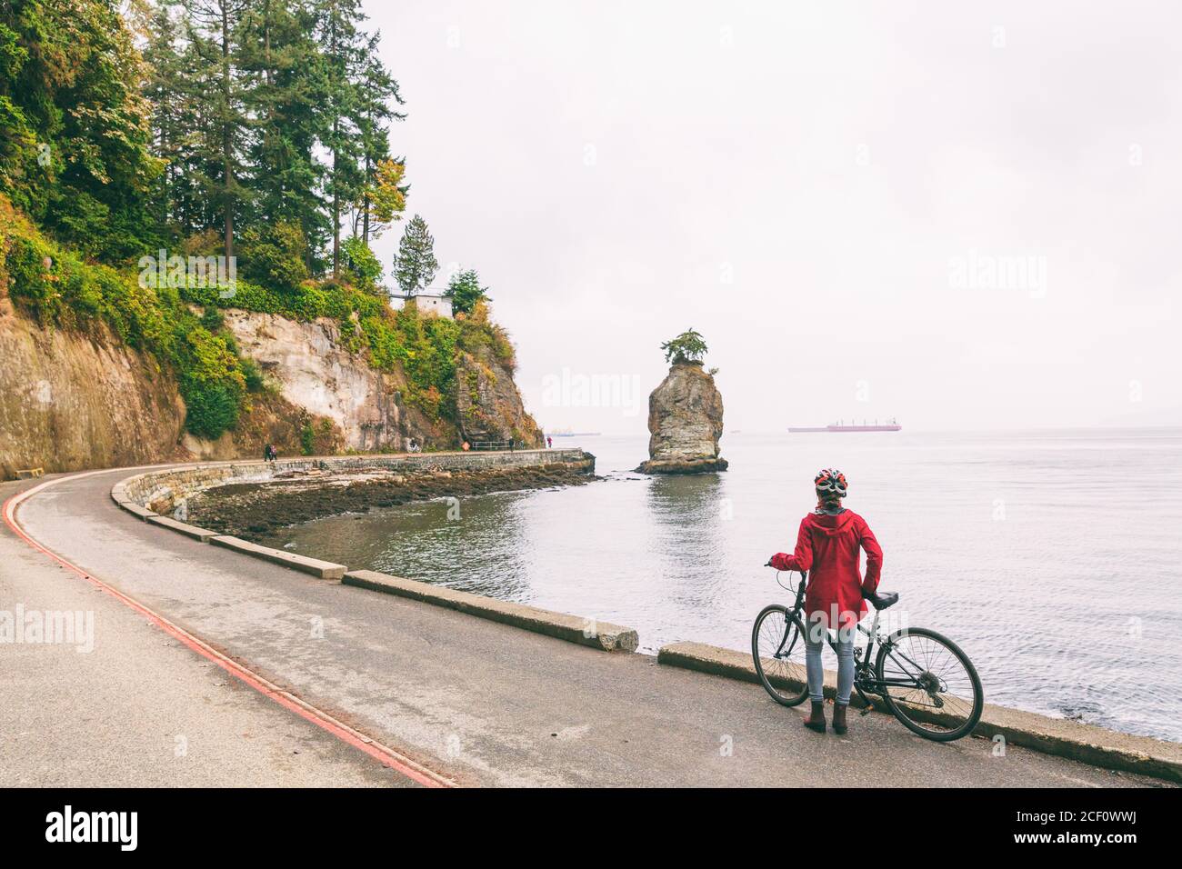 Femme cycliste de Vancouver sur une piste cyclable autour du parc Stanley, célèbre activité touristique en Colombie-Britannique, Canada. Banque D'Images