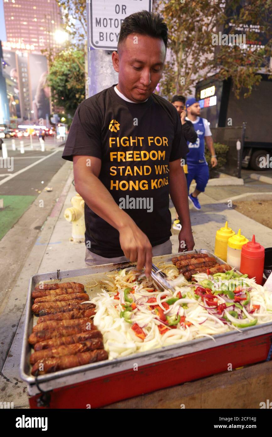 Los Angeles, Californie, États-Unis. 23 octobre 2020. Un vendeur local de produits alimentaires porte une chemise qui a été remise lors d'une manifestation contre la Chine et d'une manifestation en solidarité avec les manifestants de Hong Kong. Un homme qui passe par l'alias Sun a organisé l'événement où des chemises de soutien aux manifestants de Hong Kong ont été distribuées au Staples Center. Banque D'Images