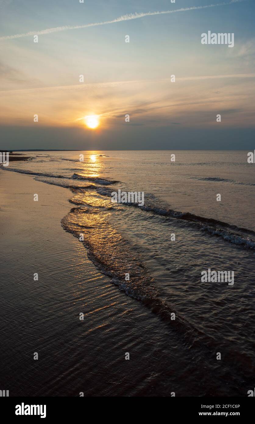 Scintillent le soleil sur les vagues. Disque solaire transitoire éblouit au-dessus d'un horizon sombre. Cavendish Beach, parc national de l'Île-du-Prince-Édouard, Canada Banque D'Images