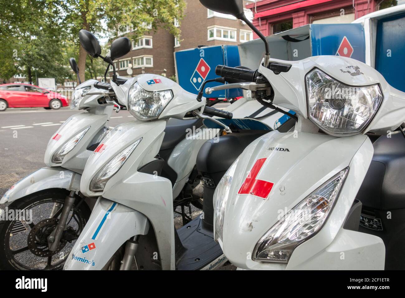 Une rangée de scooters de livraison de pizza à l'extérieur d'un restaurant de livraison rapide de Domino, Londres, Royaume-Uni Banque D'Images