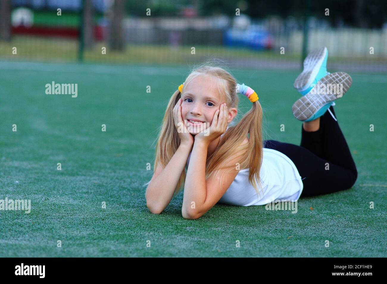 Une fille posant près d'un but de football sur un terrain de sport. Banque D'Images
