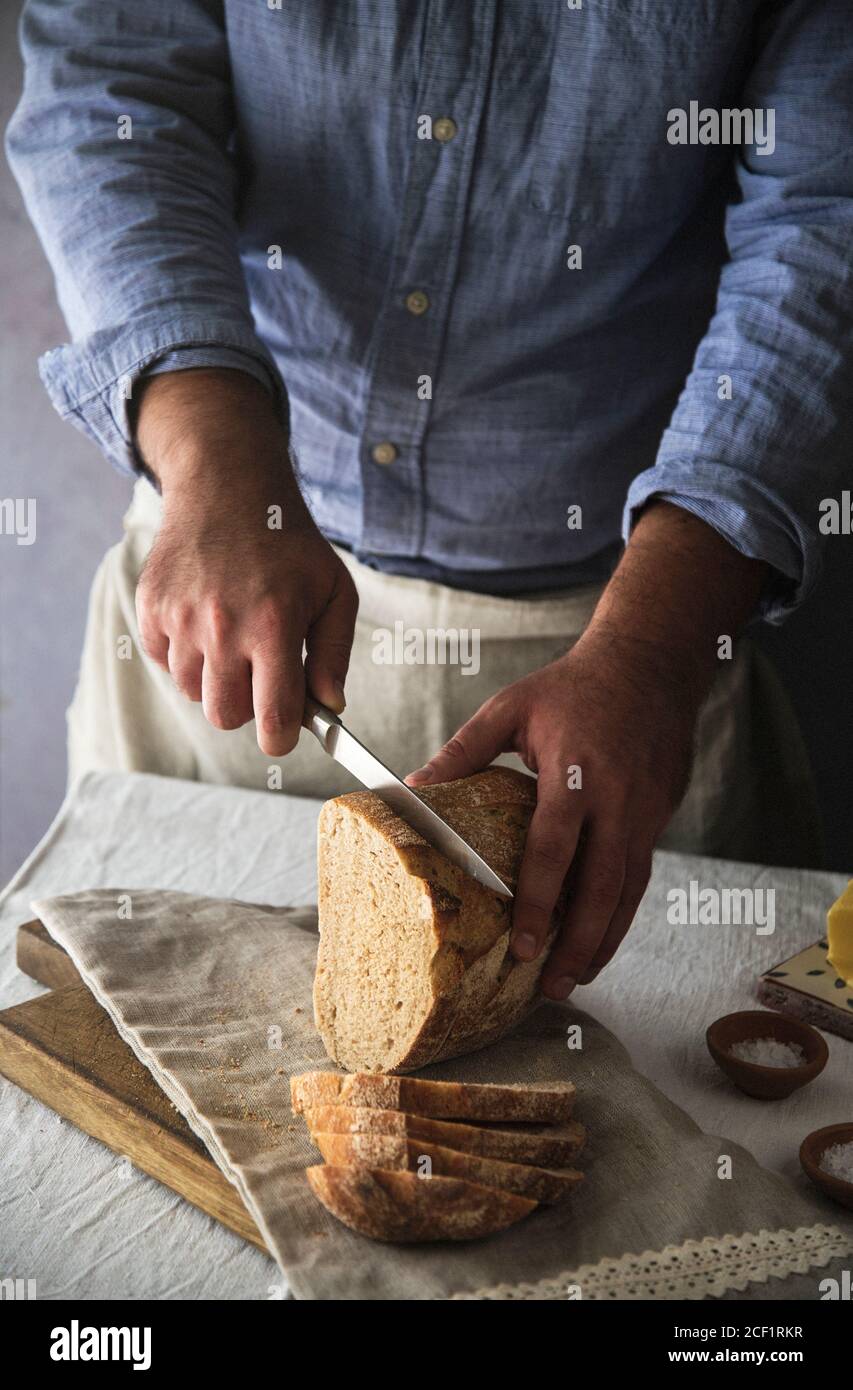 Homme en tranches de pain de levain maison frais Banque D'Images