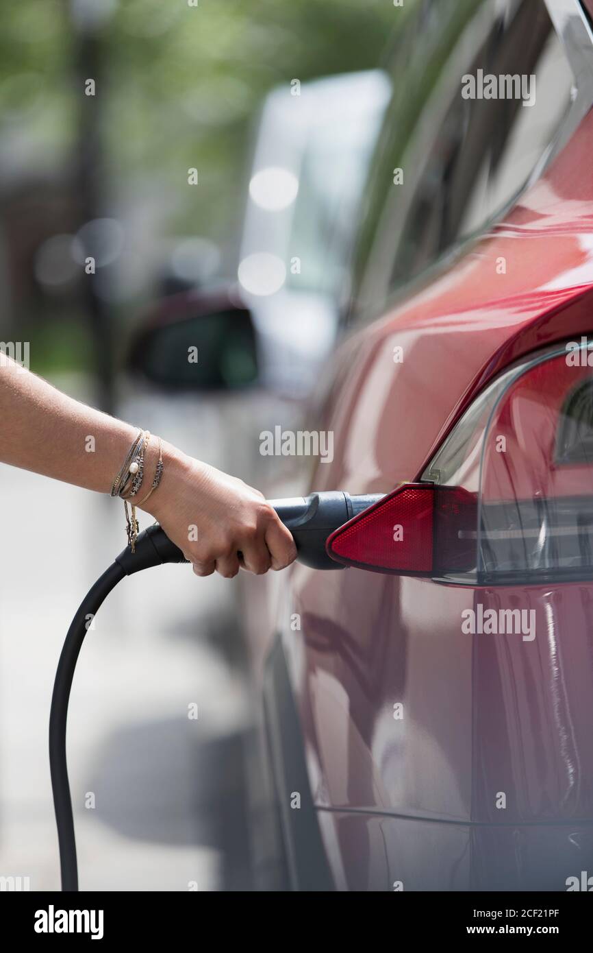 Femme recharge voiture électrique Banque D'Images