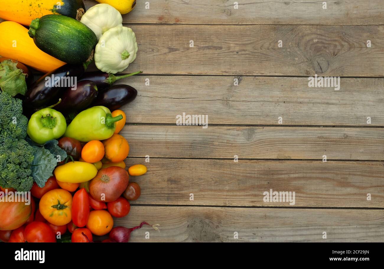 De nombreux légumes colorés et lumineux sur fond de bois. Concept de récolte et de saison d'été. Banque D'Images