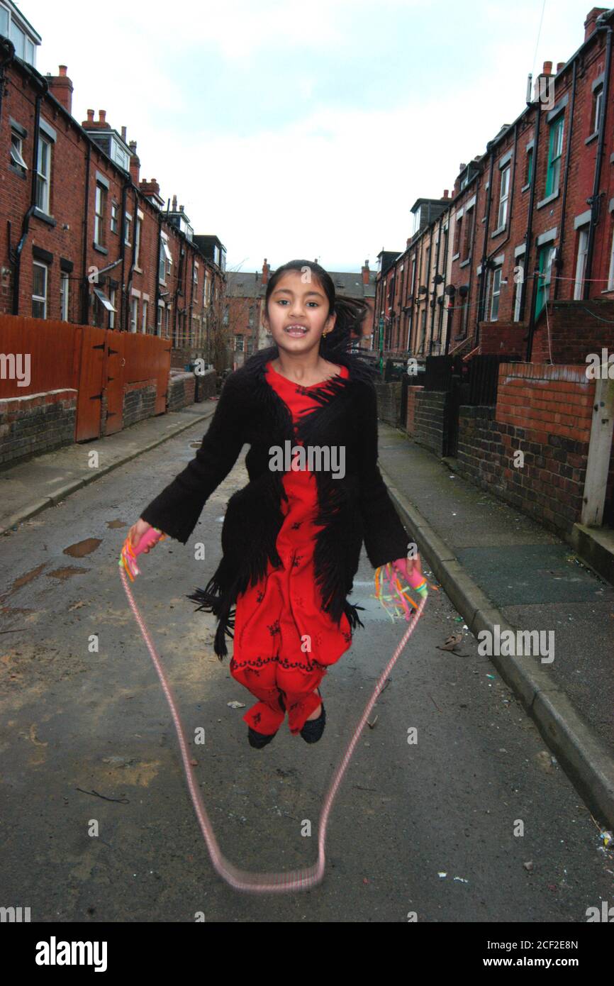 Fille à sauter; jouer dans la rue Beeston Leeds Royaume-Uni Banque D'Images