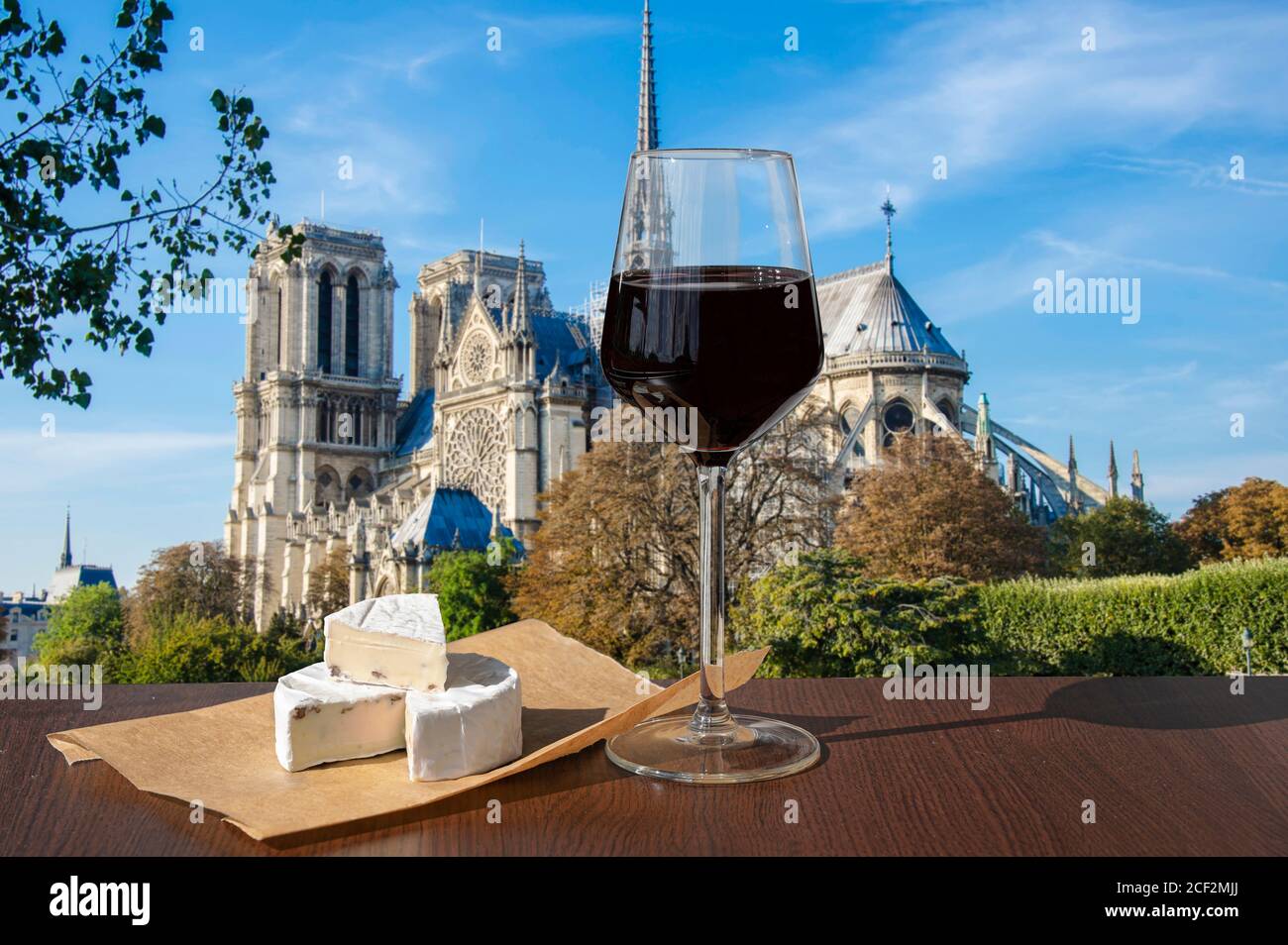 Verre de vin rouge au brie contre notre Dame de Paris ou la cathédrale notre-Dame de Paris, France. Célébration romantique. Banque D'Images