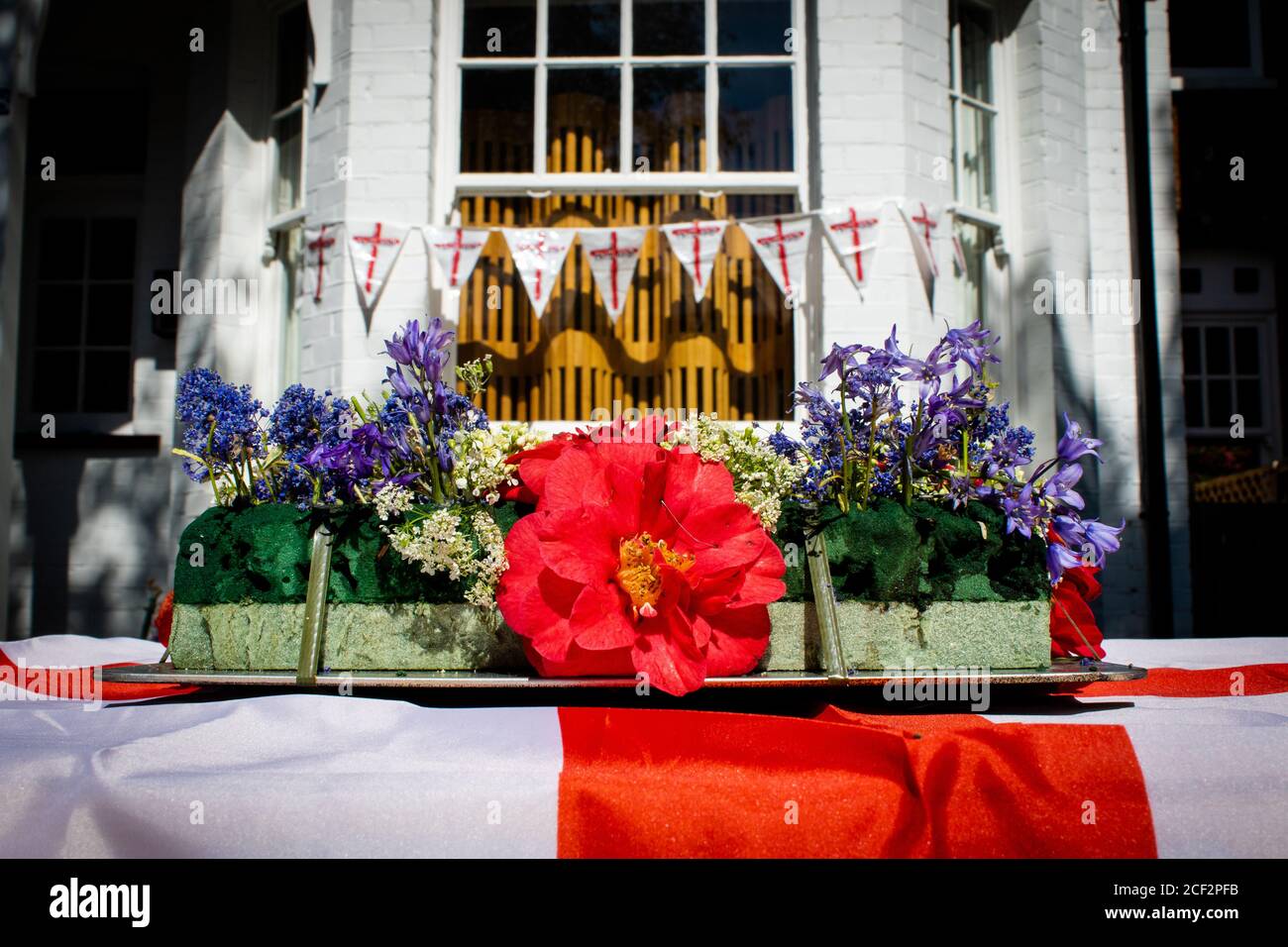 Fleurs sur une table drapées dans un drapeau d'Angleterre devant une fête de rue pour le 75e anniversaire de la Ve journée. 8 mai 2020. Chiswick, Royaume-Uni Banque D'Images