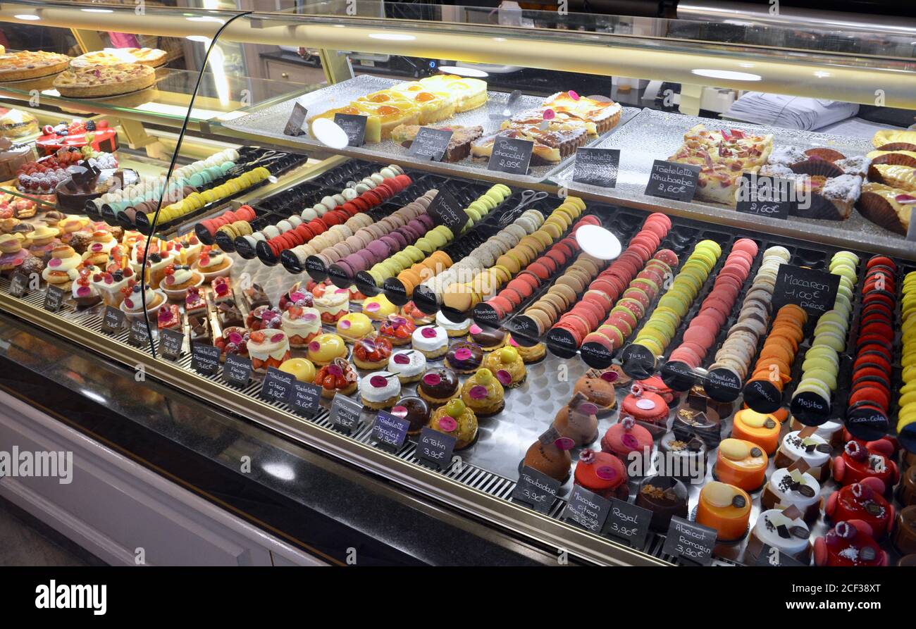 Une Variete De Patisseries Traditionnelles Colorees Et De Macarons Derriere Un Comptoir De Verre En Normandie En France Photo Stock Alamy
