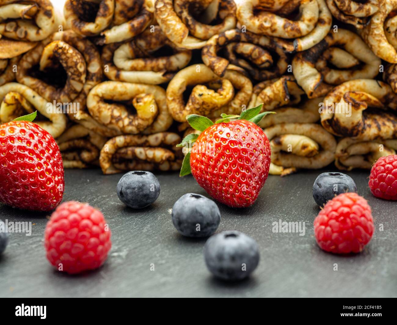 pile de crêpes avec confiture et framboises et bleuets frais sur ardoise Banque D'Images