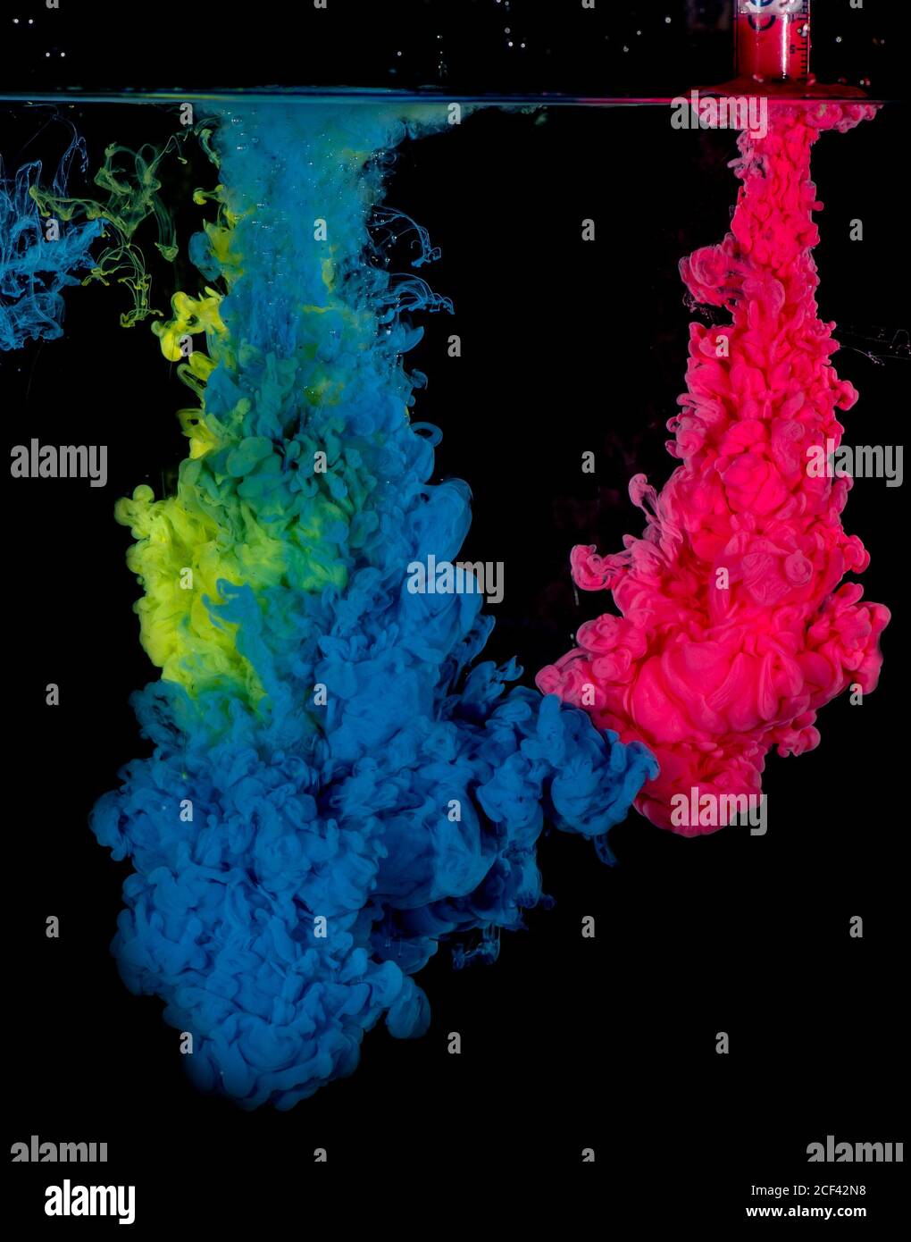 L'encre acrylique colorée se mélange dans l'eau. Explosion de couleur. Banque D'Images