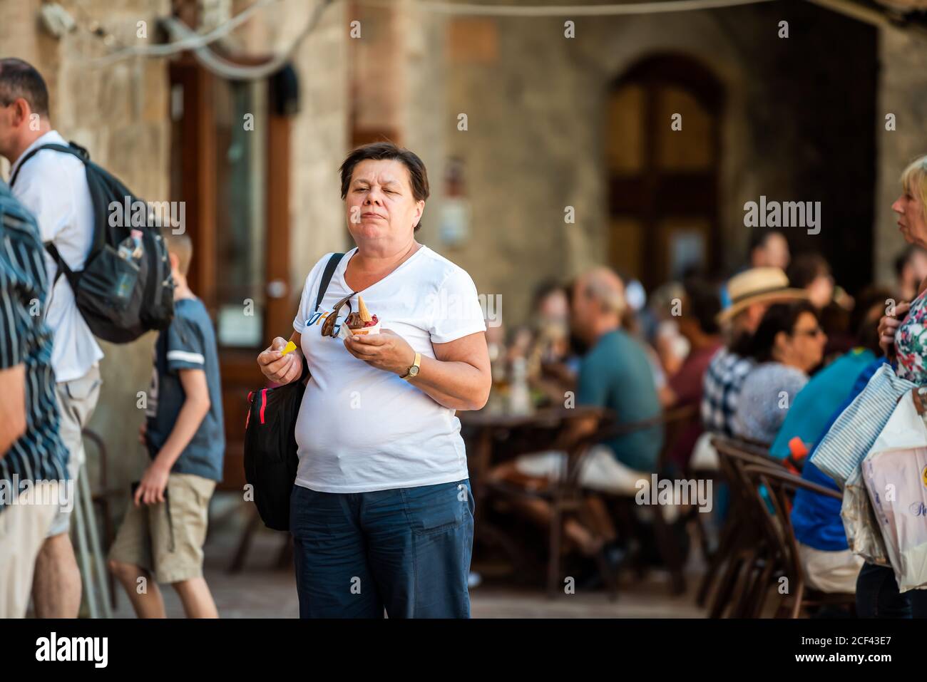 San Gimignano, Italie - le 27 août 2018 : une femme mangeant une célèbre sorbet glace à glace sur la place dans un petit village médiéval historique en Toscane Banque D'Images