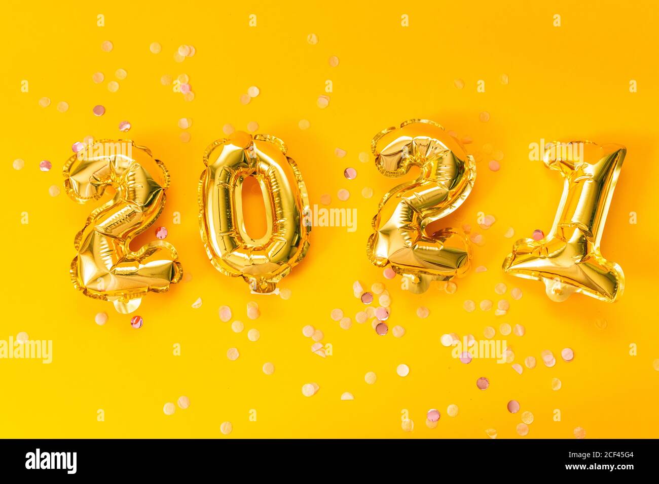 Bonne célébration du nouvel an 2021. Ballons or lumineux avec étoiles brillantes sur fond jaune. Noël et fête du nouvel an. Banque D'Images