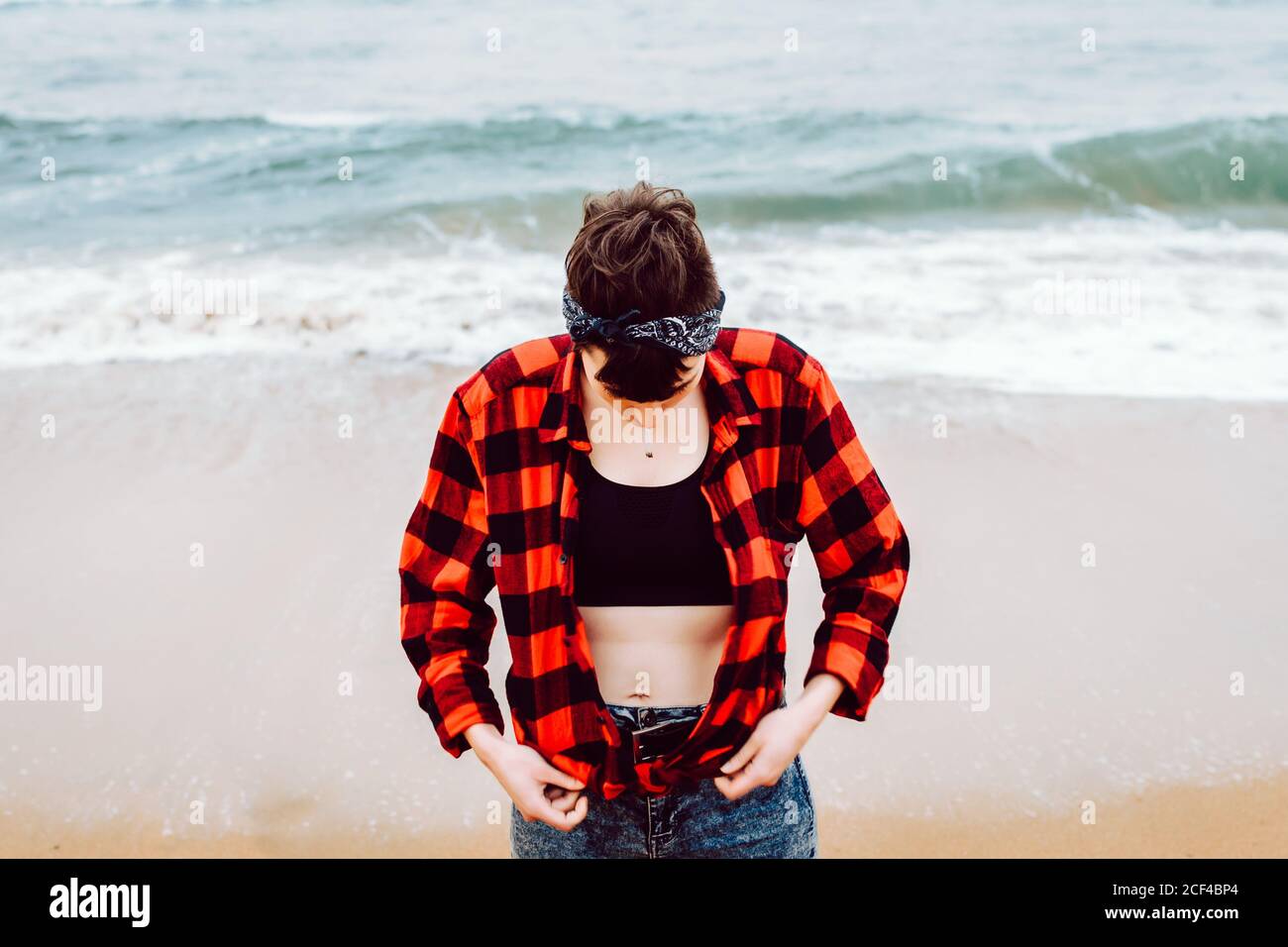 Femme debout sur le sable humide sur la plage Banque D'Images