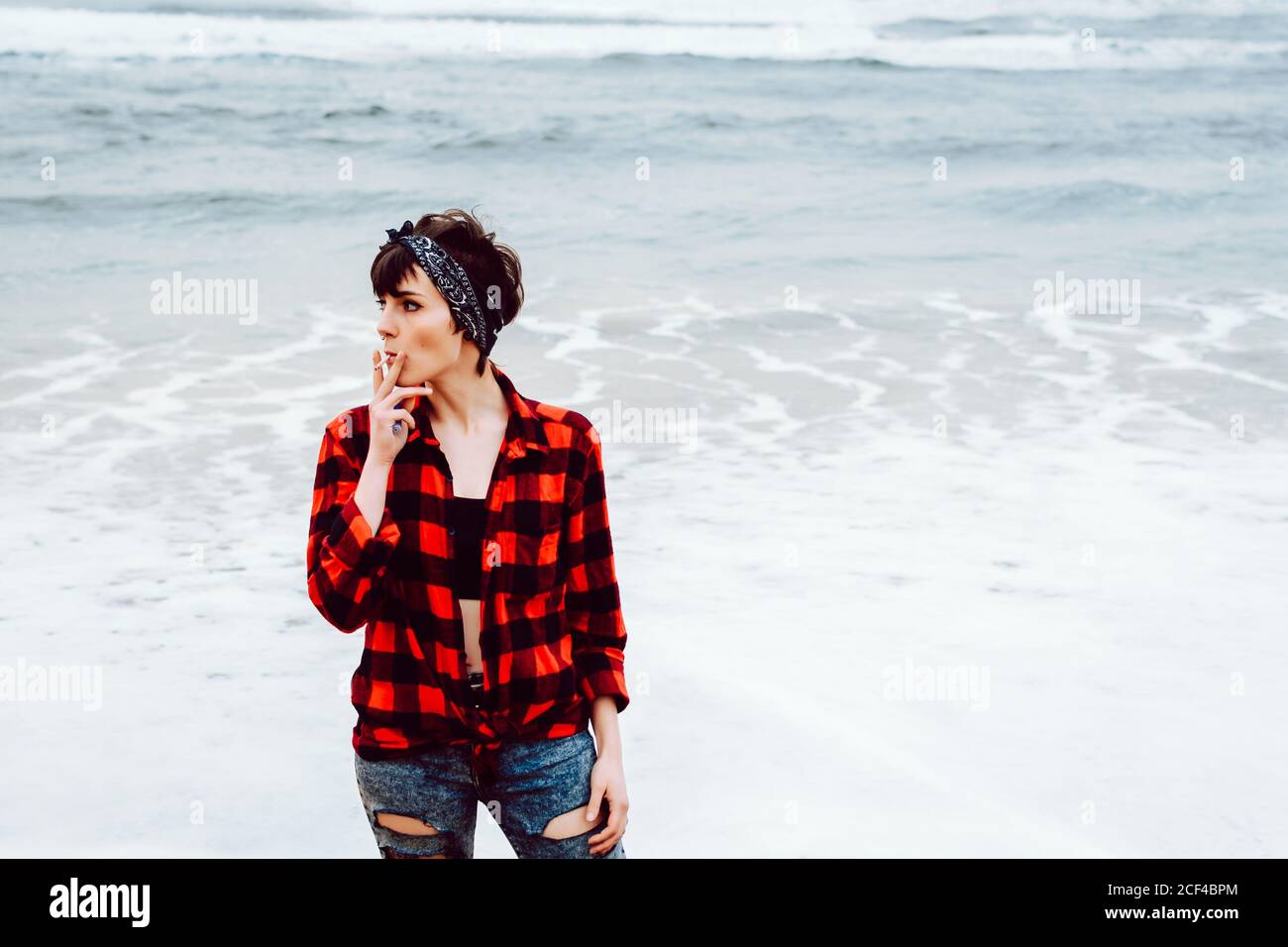 Femme cigarette on beach Banque D'Images